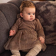 Arya participe au concours pour gagner de l'argent avec cette photo : baby, infant, child, sofa, couch, cushion, dress, tights, socks, blue_eyes, curly_hair, portrait, indoor, cozy, soft_lighting, seated, plush, textured, hands, feet