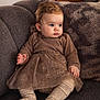 Arya participe au concours pour gagner de l'argent avec cette photo : baby, infant, child, sofa, couch, cushion, dress, tights, socks, blue_eyes, curly_hair, portrait, indoor, cozy, soft_lighting, seated, plush, textured, hands, feet