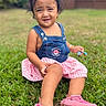 Tania is registered to the contest to win money with this photo: casual_clothing, child, cute, daylight, denim, dress, expression, fence, garden, grass, greenery, happy, outdoor, pink_shoes, portrait, sitting, small_object, summer, toddler, young_child