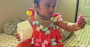 Tania is registered to the contest to win money with this photo: accessories, baby, bed, blanket, bows, candid, child, curious, fabric, foot, hand, indoor, natural_light, orange_clothing, person, playing, portrait, room, toddler, window