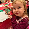 Alina joined the competition — help win amazing prizes! child, girl, cookie, gingerbread, decorating, table, holiday, craft, party, smile, happy, indoors, people, background, red_tablecloth, clothing, face, celebration, fun, event