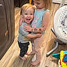 toddler, child, hug, smiling, indoor, flooring, tattoos, barefoot, clothing, happy, playful, kitchen, furniture, wooden_floor, person, young_child, affection, cute, family, love