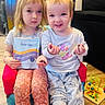 child, children, indoor, toy, bead_maze, chair, clothing, pajamas, gummies, packet, floor, home, smiling, sitting, person, cute, playful, young, kids, face