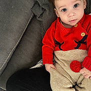 Jules a rejoint le concours — aidez-le/la à gagner de superbes lots ! baby, child, infant, red_sweater, knitwear, couch, blanket, indoor, portrait, cute, face, eyes, hand, furniture, cozy, sitting, clothing, person, home, relaxing