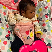 Jazmin is registered to the contest to win money with this photo: baby, infant, child, portrait, seated, baby_seat, harness, minnie_mouse, cartoon, colorful, pink, polka_dots, hearts, stars, blanket, indoor, home, face, dark_hair, sticker