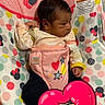 baby, infant, child, portrait, seated, baby_seat, harness, minnie_mouse, cartoon, colorful, pink, polka_dots, hearts, stars, blanket, indoor, home, face, dark_hair, sticker