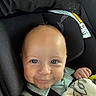 baby, child, car_seat, blanket, smile, face, blue_eyes, clothing, infant, cute, human, portrait, seatbelt, indoor, baby_girl, baby_boy, head, hand, young_child, comfort
