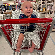 Axton joined the competition — help win amazing prizes! baby, shopping_cart, blanket, smile, child, store, aisle, clothing, home_goods, sitting, happy, infant, retail, retail_store, person, footwear, furniture, shopping, baby_clothes, indoor