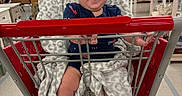 Axton joined the competition — help win amazing prizes! aisle, baby, baby_clothes, blanket, child, clothing, footwear, furniture, happy, home_goods, indoor, infant, person, retail, retail_store, shopping, shopping_cart, sitting, smile, store