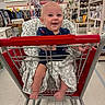 baby, shopping_cart, blanket, smile, child, store, aisle, clothing, home_goods, sitting, happy, infant, retail, retail_store, person, footwear, furniture, shopping, baby_clothes, indoor