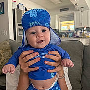 Axton joined the competition — help win amazing prizes! baby, blue_clothing, blue_hat, casual, child, couch, cute, diaper, face, hands, happy, holding, indoor, infant, kitchen, modern_home, person, portrait, sitting, smile