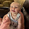 Oaklynn is registered to the contest to win money with this photo: baby, child, smiling, blanket, couch, armchair, indoor, happy, cute, infant, person, portrait, seated, clothing, soft, living_room, cozy, expression, skin, furniture