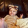 Oaklynn joined the competition — help win amazing prizes! baby, child, infant, headband, bow, floral_clothing, couch, leather, blanket, smile, face, hand, portrait, indoors, comfortable, cute, young_child, seated, cozy, playful