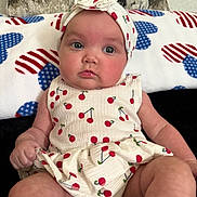Ariel is registered to the contest to win money with this photo: baby, infant, child, face, headband, clothing, pattern, cherry, sitting, blanket, heart_pattern, cute, portrait, skin, expression, indoors, person, fashion, headwear, eyes