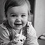 baby, black_and_white, child, closeup, clothing, cute, expression, eyes, face, hand, happy, holding, indoors, infant, person, playing, portrait, smile, toy, young_child
