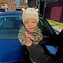 baby, child, smiling, hat, knitted_hat, camouflage_clothing, person, outdoor, car, blue_car, daylight, urban, street, holding, happy, cute, face, headwear, infant, joyful