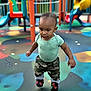 Apollo is registered to the contest to win money with this photo: active, baby, camouflage_pants, child, climbing_structure, colorful, daylight, fun, green_shirt, kid, outdoor, park, person, play_area, playground, shoes, slide, toddler, walking, young_child