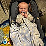 baby, blanket, car_seat, child, clothing, comfort, couch, cozy, face, home, indoor, infant, pacifier, person, plush_blanket, rug, seatbelt, smiling, soft_toy, toy