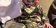 Finlay joined the competition — help win amazing prizes! baby, blanket, child, clothing, comfort, couch, cute, dinosaur_pattern, face, hand, home, indoor, infant, pacifier, pajamas, person, relaxed, sitting, tissue, wooden_wall