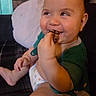 Dawson is registered to the contest to win money with this photo: baby, child, smiling, eating, food, hand, face, couch, pillow, indoor, clothing, diaper, cute, happy, skin, person, sitting, infant, mouth, furniture