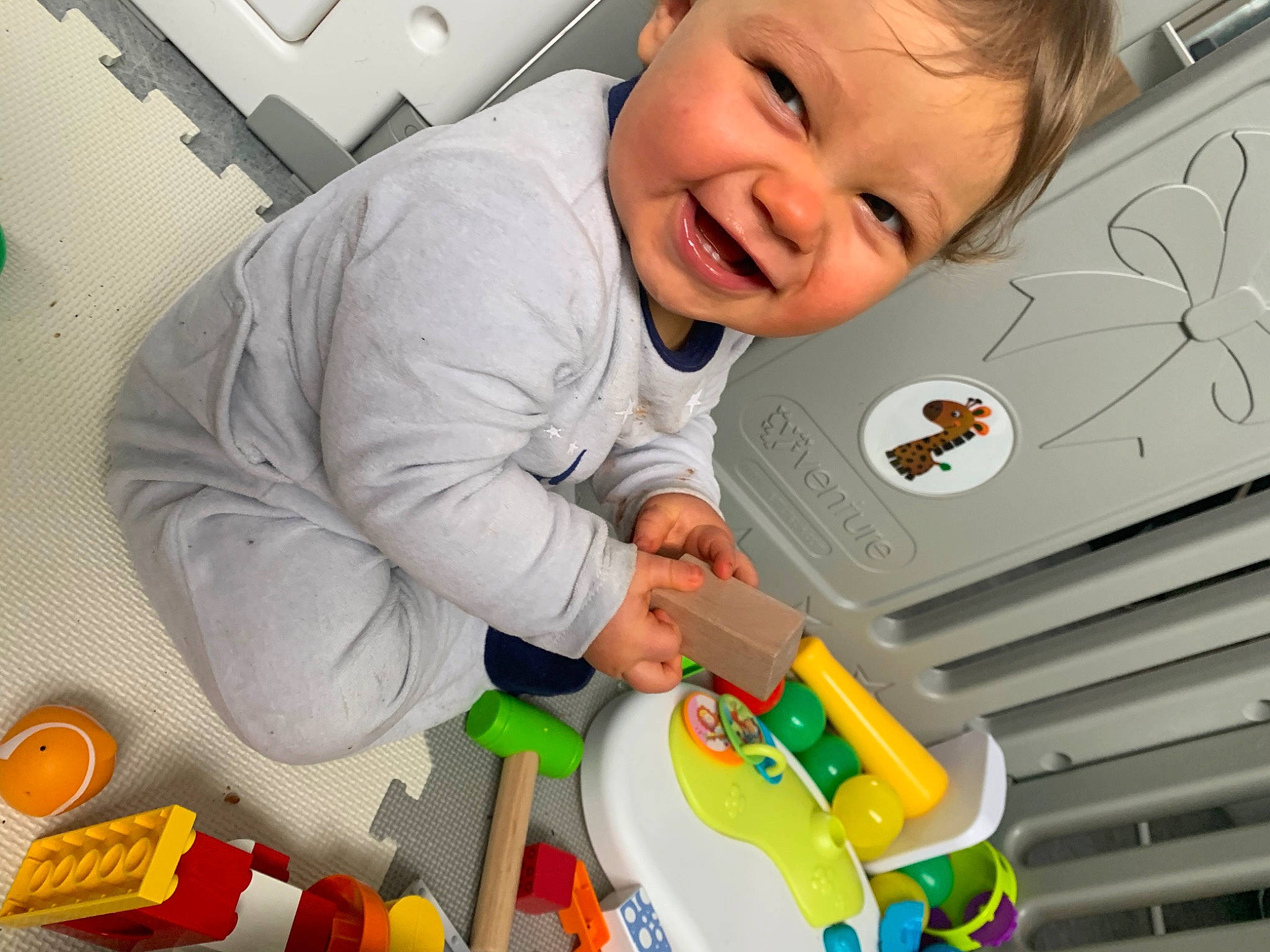 Malhon participe au concours pour gagner de l'argent avec cette photo : baby, baby_playing_with_toys, baby_products, baby_toddler_clothing, child, face, flooring, fun, happy, orange, person, plastic, product, room, sleeve, smile, t_shirt, toddler, toy, wheel