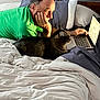 Buddy is registered to the contest to win money with this photo: man, cat, bed, laptop, pillow, blanket, indoor, technology, pet, tabby_cat, person, home, resting, furniture, sleepwear, computer, casual, relaxation, typing, white_bedding