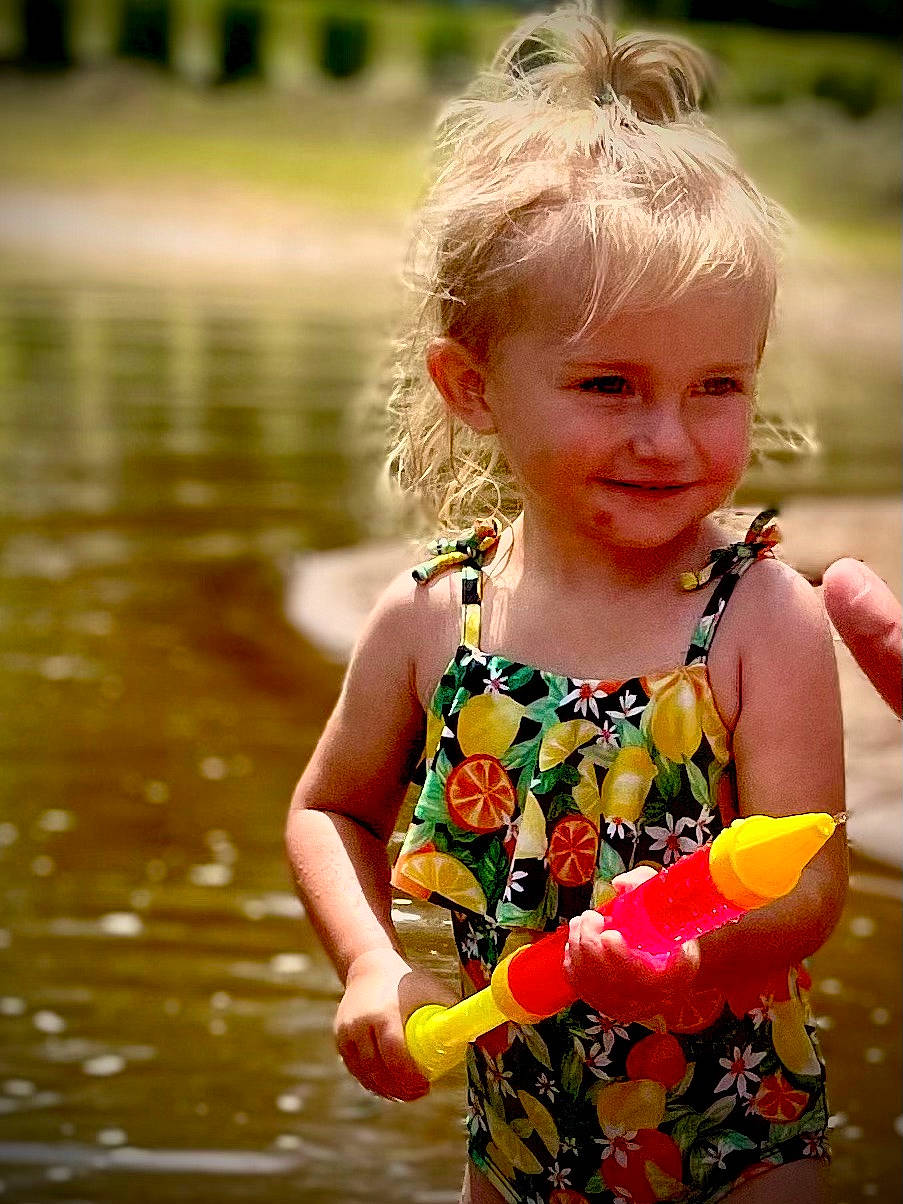 Madeline Grace is registered to the contest to win money with this photo: baby_toddler_clothing, blond, child, eye, fun, gesture, grass, happy, iris, joy, lake, leisure, pattern, people_in_nature, person, skin, sleeve, smile, sunlight, t_shirt