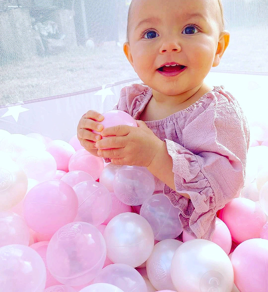 Mya a rejoint le concours — aidez-le/la à gagner de superbes lots ! arm, baby, baby_playing_with_toys, baby_toddler_clothing, balloon, cheek, facial_expression, finger, gesture, happy, headwear, human, human_body, lip, organ, person, photograph, pink, skin, sleeve