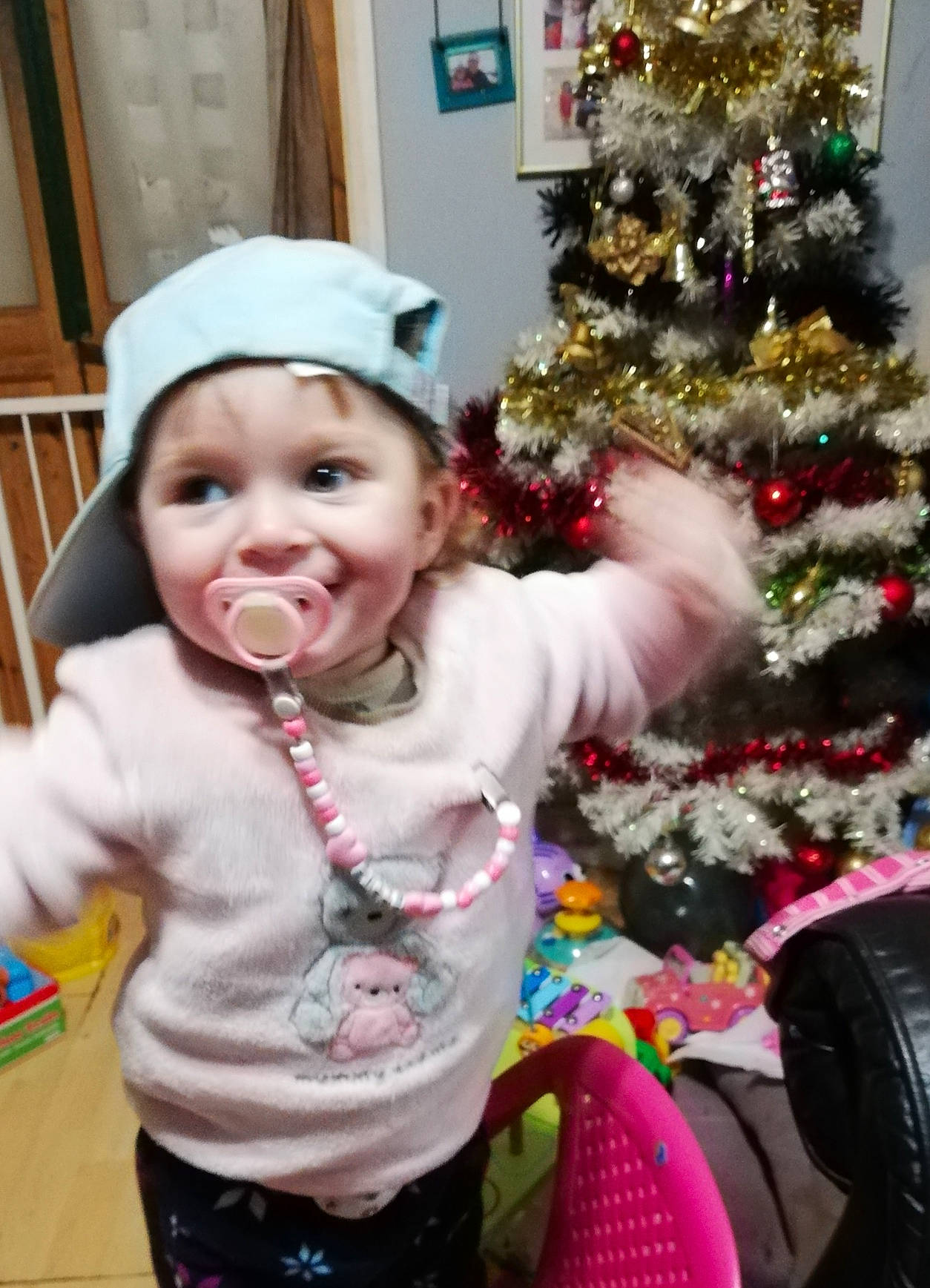Ellie Rose is registered to the contest to win money with this photo: baby, baby_toddler_clothing, christmas, christmas_decoration, christmas_eve, christmas_ornament, christmas_tree, event, facial_expression, happy, head, headwear, holiday, holiday_ornament, joy, ornament, person, plant, sleeve, smile
