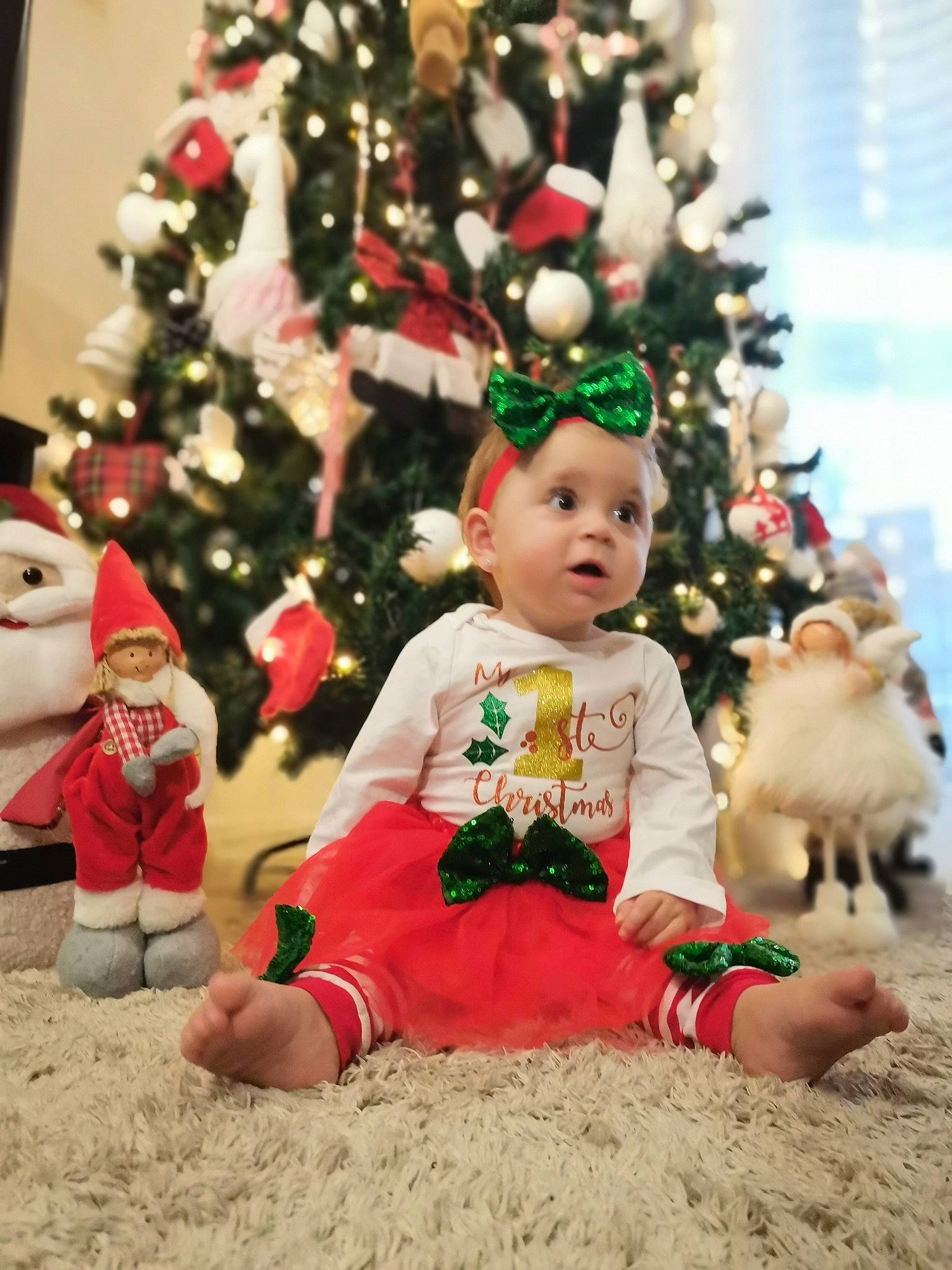 Vladiana participe au concours pour gagner de l'argent avec cette photo : baby, baby_toddler_clothing, christmas, christmas_decoration, christmas_ornament, christmas_tree, conifer, event, evergreen, grass, happy, hat, holiday, holiday_ornament, mammal, ornament, person, plant, surprise, toddler