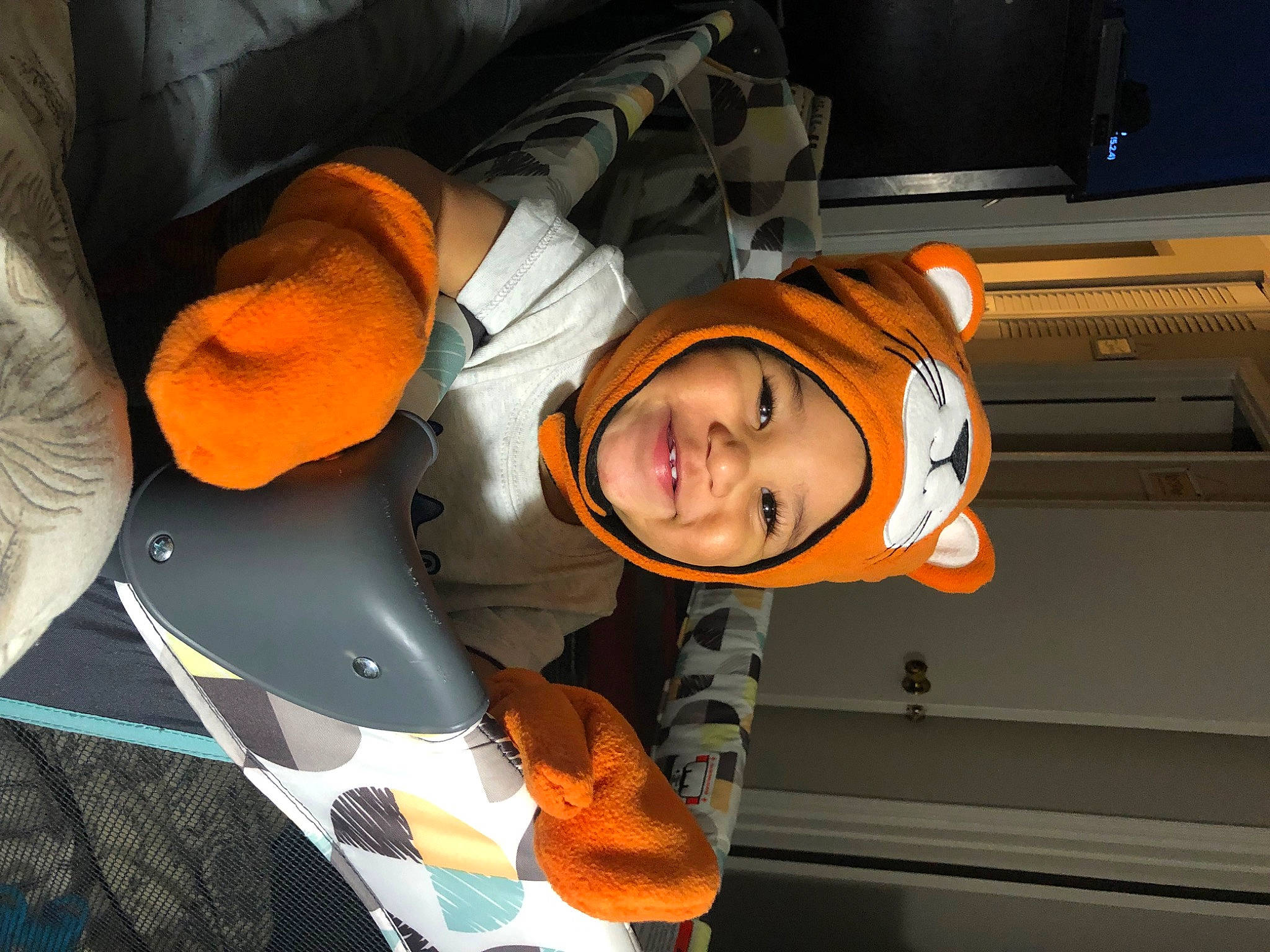 Kyng is registered to the contest to win money with this photo: child, comfort, computer_keyboard, costume, fun, happy, hat, headwear, orange, person, personal_protective_equipment, room, smile, toddler