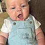 baby, child, infant, overalls, blue_clothing, sitting, couch, leather, home_interior, cute, expression, face, mouth_open, button, pocket, person, skin, arm, white_shirt, indoors