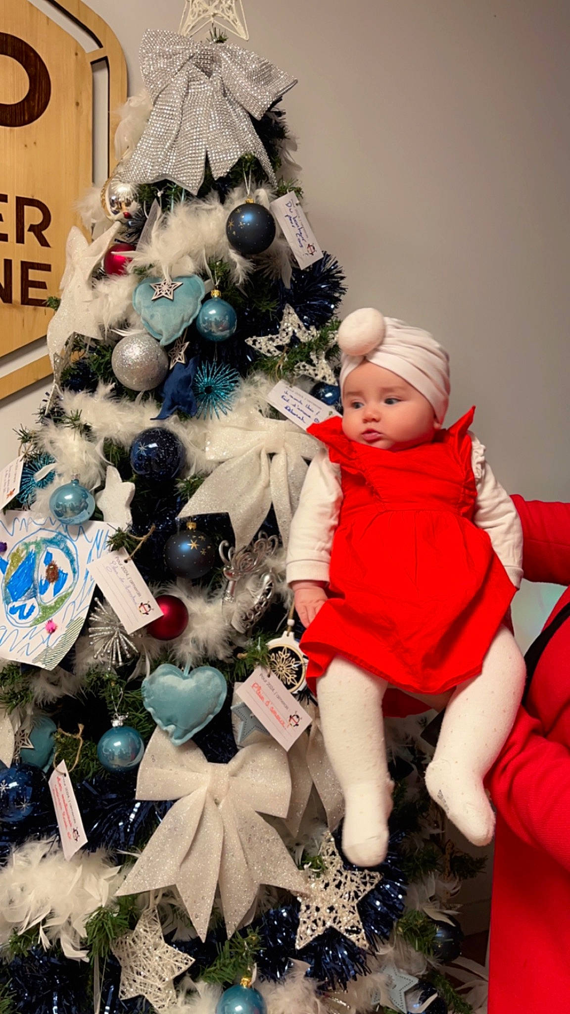 Medina a rejoint le concours — aidez-le/la à gagner de superbes lots ! christmas, christmas_decoration, christmas_eve, christmas_ornament, christmas_tree, conifer, event, evergreen, happy, hat, headwear, holiday, holiday_ornament, lap, ornament, person, room, toddler, toy, tradition