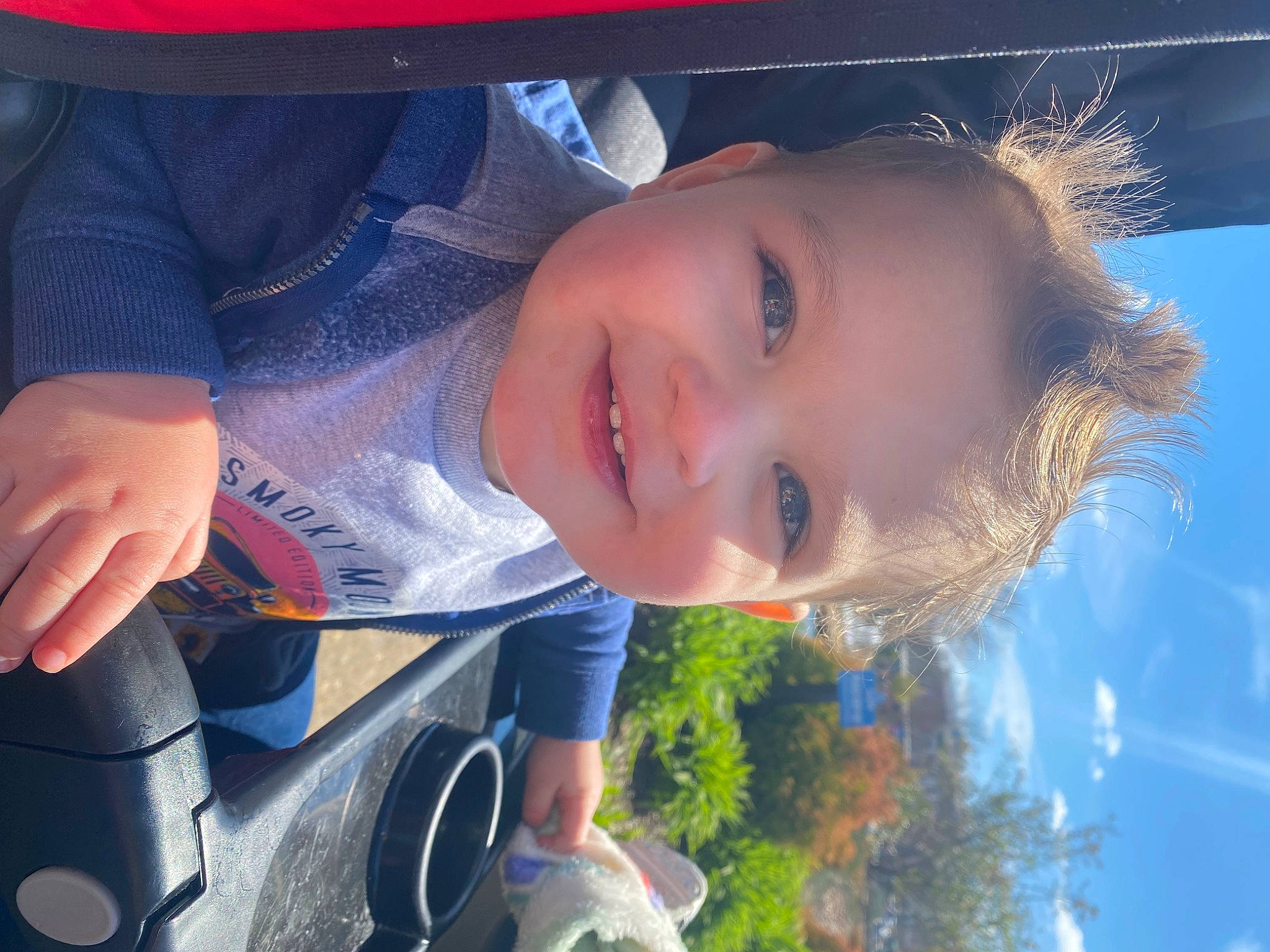 Bentley is registered to the contest to win money with this photo: azure, cloud, cool, eyelash, facial_expression, flash_photography, grass, happy, iris, joy, light, lip, mouth, nose, person, skin, sky, smile, sunlight, toddler