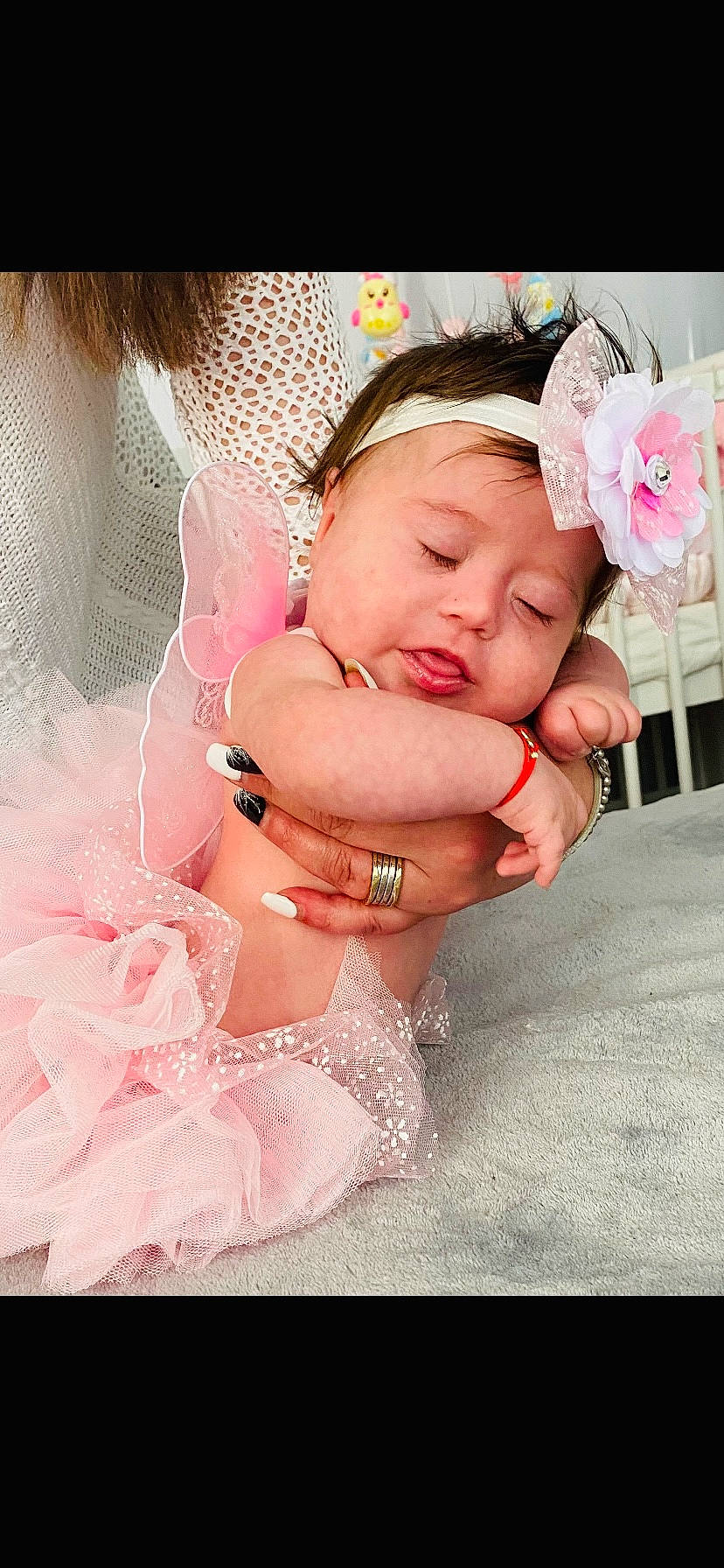 Amalia Elena Martinica is registered to the contest to win money with this photo: arm, baby, baby_toddler_clothing, dress, eyelash, finger, flower, gesture, hand, happy, headgear, headpiece, headwear, interaction, nail, person, petal, pink, skin, textile