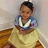baby, barefoot, child, costume, cute, dress, floor, hair_bow, happy, head, indoor, person, portrait, sitting, smile, snow_white, toddler, wall, wood_floor, young_child
