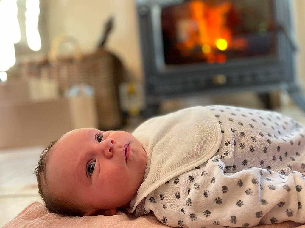 Julyan participe au concours pour gagner de l'argent avec cette photo : baby, baby_safety, baby_sleeping, baby_toddler_clothing, child, comfort, fire, fireplace, flooring, gas, hearth, heat, home_appliance, person, room, skin, sleeve, stove, toddler, wood