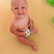 Benny is registered to the contest to win money with this photo: baby, infant, child, smiling, sitting, pool, water, diaper, portrait, face, bald, playful, outdoor, swimming, pool_toy, green_toy, wet, happy, closeup, photography
