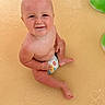baby, infant, child, smiling, sitting, pool, water, diaper, portrait, face, bald, playful, outdoor, swimming, pool_toy, green_toy, wet, happy, closeup, photography