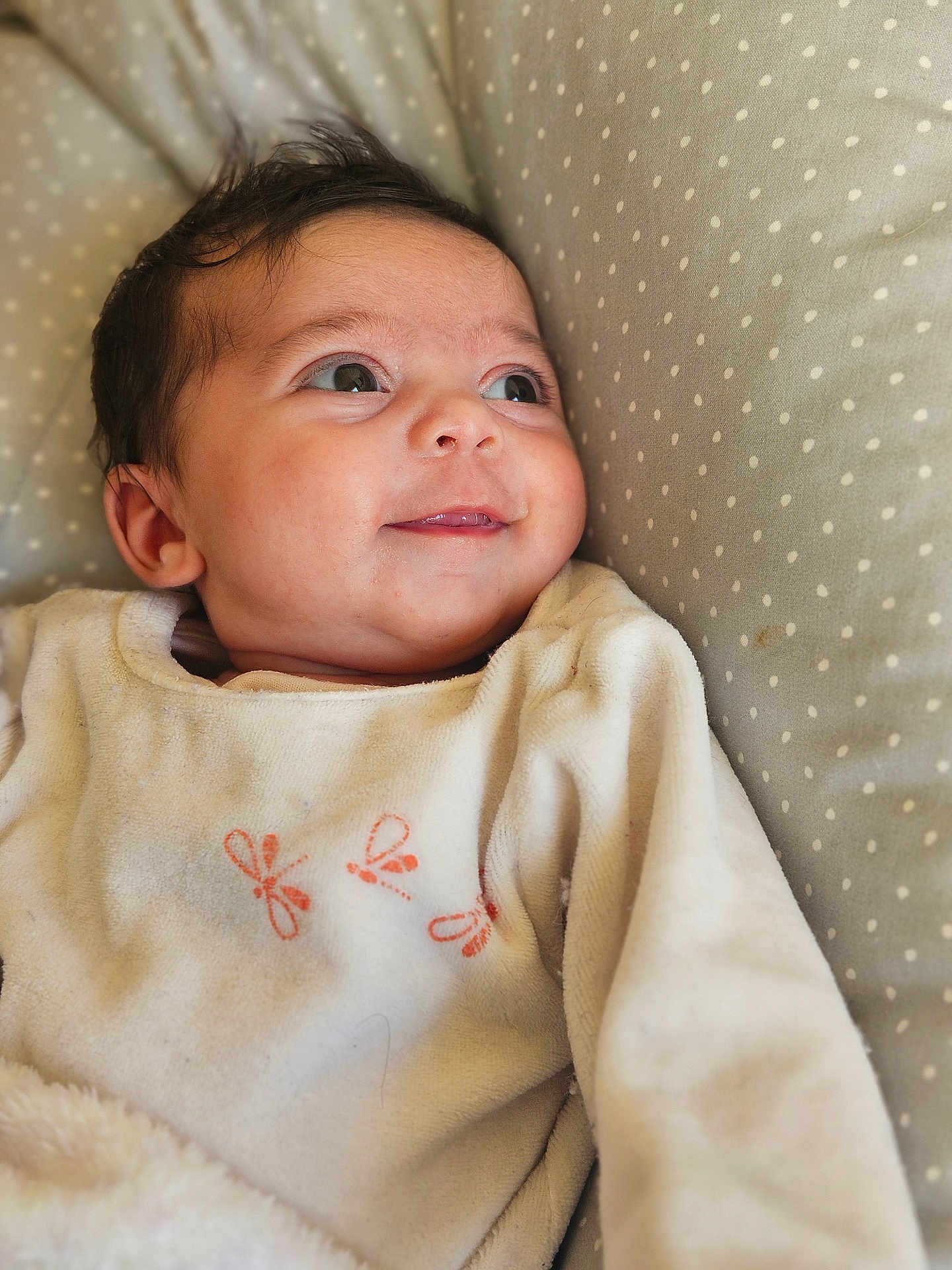 Alméa participe au concours pour gagner de l'argent avec cette photo : baby, infant, smile, face, clothing, polka_dot, cushion, soft, cute, child, sleepwear, portrait, young, skin, expression, lying_down, indoors, warm, eyes, head