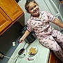 Ezra is registered to the contest to win money with this photo: child, pajamas, kitchen, marshmallows, smores, countertop, electric_stove, plate, food, happy, smiling, indoor, appliance, refrigerator, cabinet, person, cooking, snack, cozy, roasting