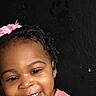 child, toddler, smiling, face, pink_bow, pink_shirt, portrait, happy, cute, dark_background, curly_hair, person, young_child, innocence, closeup, head_and_shoulders, skin, expression, joyful, casual_clothing