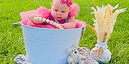 Emmalee is registered to the contest to win money with this photo: baby, pink_dress, bucket, grass, outdoor, toy, teddy_bear, headband, beads, vase, dried_flowers, greenery, tree, blanket, cute, child, summer, nature, playful, portrait