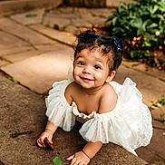 Tommie joined the competition — help win amazing prizes! toddler, child, smile, white_dress, outdoor, crawling, stone_path, greenery, sunlight, curly_hair, happy, cute, nature, baby, portrait, young_child, playful, garden, innocence, person