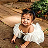 toddler, child, smile, white_dress, outdoor, crawling, stone_path, greenery, sunlight, curly_hair, happy, cute, nature, baby, portrait, young_child, playful, garden, innocence, person