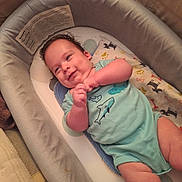 Brandon joined the competition — help win amazing prizes! baby, infant, smiling, onesie, bassinet, blanket, indoor, cute, child, person, sleeping_area, soft_fabric, plush, happy, small_hands, head, face, skin, clothing, resting