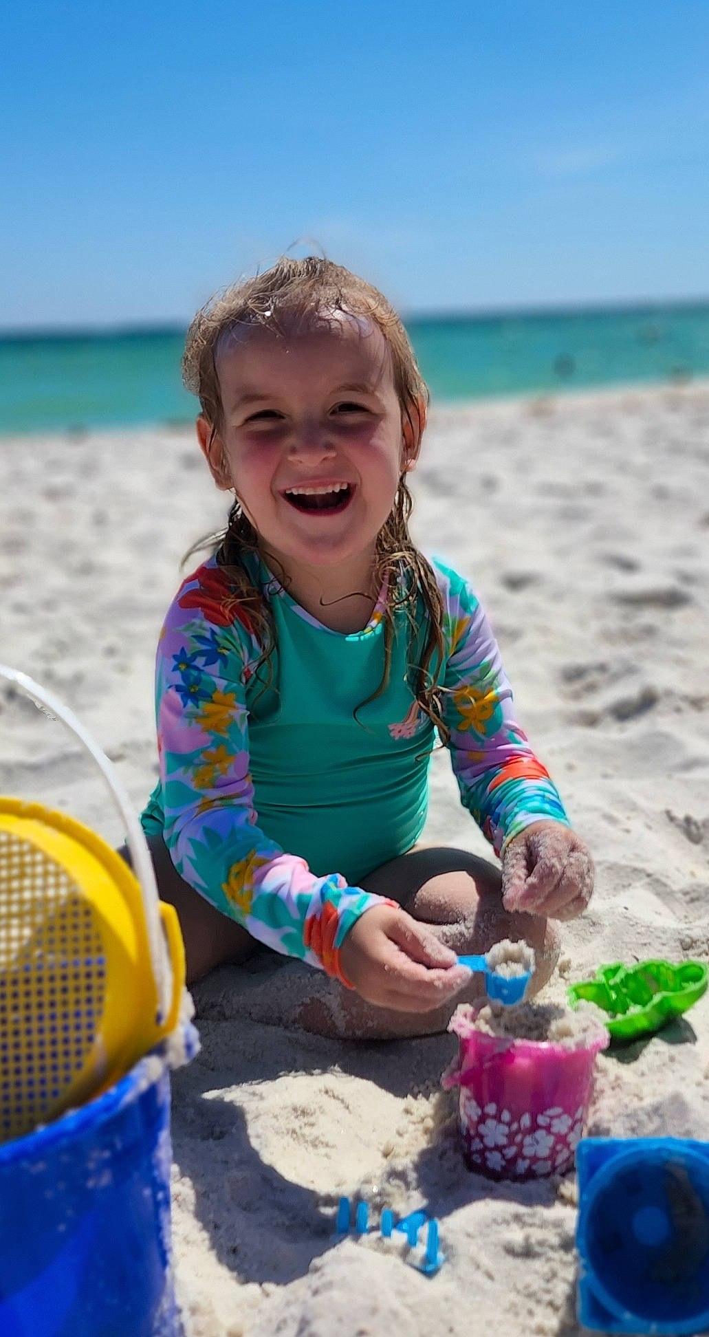 Emilia is registered to the contest to win money with this photo: beach, blue, child, coast, event, fun, happy, holiday, joy, leisure, people_in_nature, people_on_beach, person, recreation, sand, sitting, sky, smile, summer, toddler