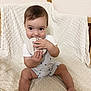 baby, child, infant, sitting, blanket, wooden_disc, teething, cute, indoors, person, clothing, shorts, white_shirt, face, hand, foot, texture, light, skin, expression
