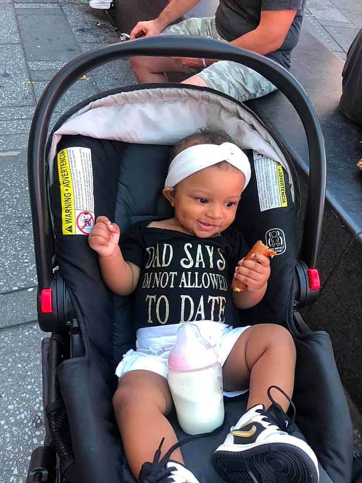 Jojo is registered to the contest to win money with this photo: auto_part, baby, baby_carriage, baby_products, baby_toddler_clothing, bag, car_seat, child, comfort, event, fun, hat, lap, motor_vehicle, person, shoe, sitting, sock, thigh, tire