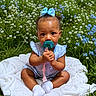 baby, child, pacifier, blue_bow, striped_clothing, white_blanket, wildflowers, grass, outdoor, cute, sitting, infant, nature, greenery, blue_flowers, white_flowers, curly_hair, sock, summer, portrait